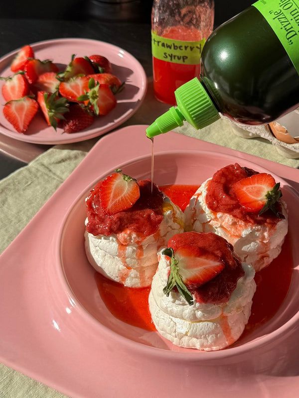 “Drizzle” squeezed over pavlovas with strawberries